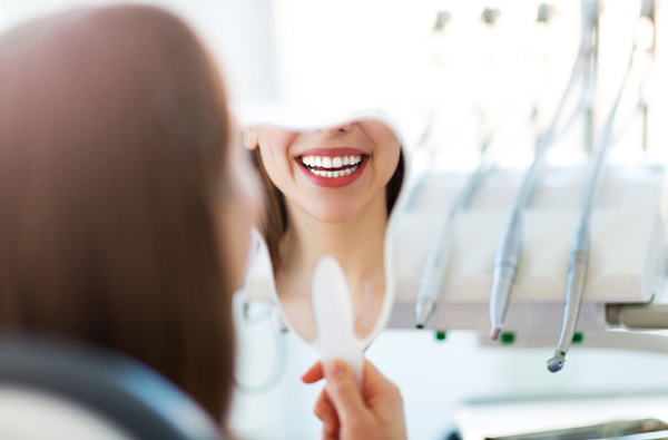 Woman looking at her smile in a mirror